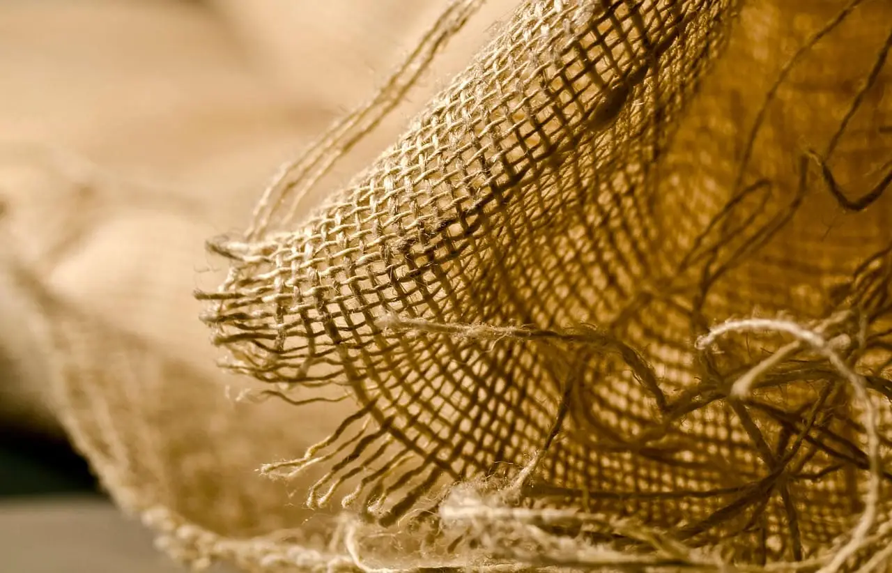 Close-up of a coarse woven fabric with a loose, frayed weave.