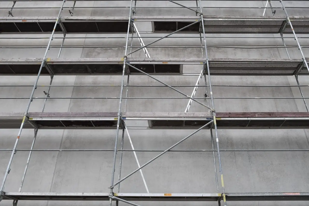 Scaffolding wrapped around the facade of a high-rise building under construction.
