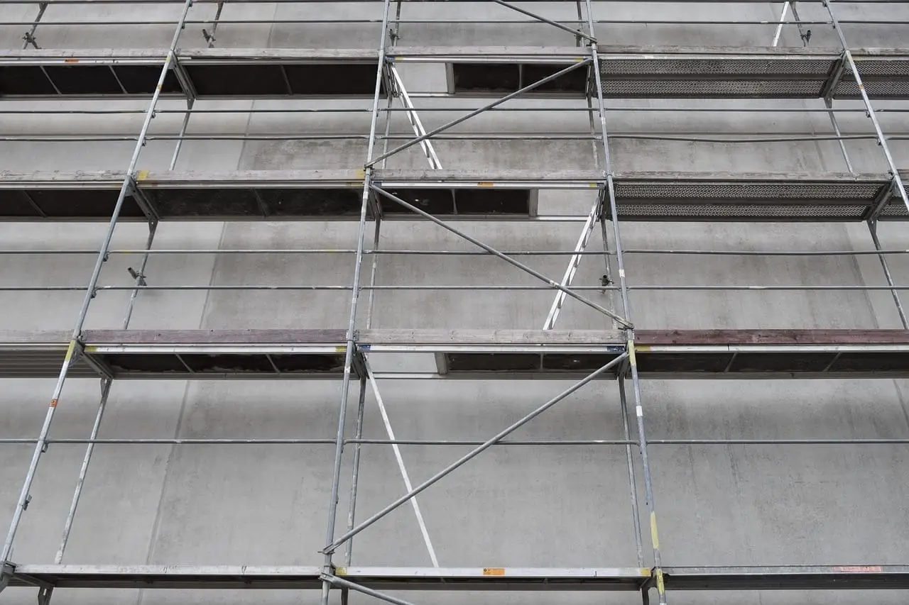 Scaffolding wrapped around the facade of a high-rise building under construction.
